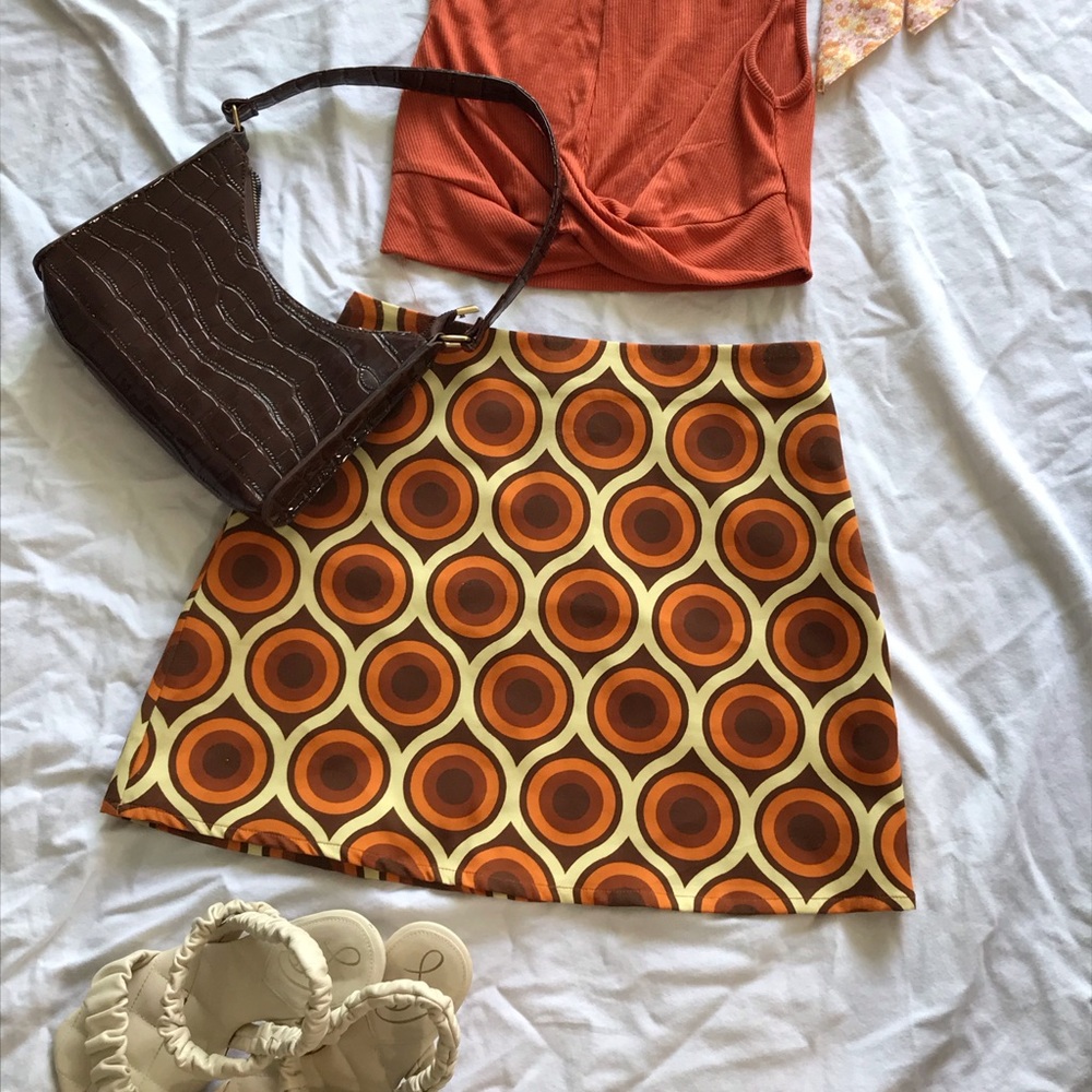 Hippy 70’s style stretchy mini skirt, orange, yellow, brown, and white pattern